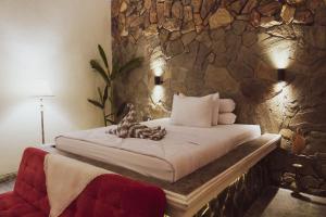 una camera con un letto e un muro in pietra di Villa Kamar Tamu Selomartani a Sleman