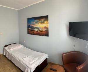 a small room with a bed and a flat screen tv at Noclegi Ciesiul in Orneta