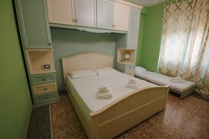 ローマにあるAppartamenti Romolo E Remoの緑の壁の小さなベッドルーム(ベッド2台付)