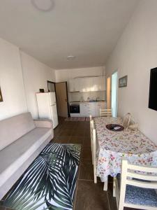 a living room with a table and a kitchen at Sea view apartament in Sarandë