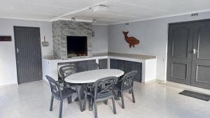 a dining room with a table and chairs and a fireplace at Sit-en-Kyk in Hermanus