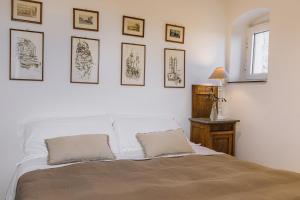 ein Schlafzimmer mit einem weißen Bett mit Bildern an der Wand in der Unterkunft Casa Sant'Anna Agriturismo in San Bartolomeo al Mare