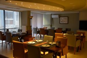a dining room with tables and chairs and a television at Grand Park Hotel Corlu City Center Bed and Breakfast in Çorlu