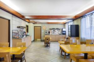 a restaurant with tables and chairs and a kitchen at La Quinta by Wyndham Helena in Helena