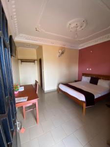 a hotel room with a bed and a table at Britannia Hôtel Cmr in Yaoundé +49 photos
