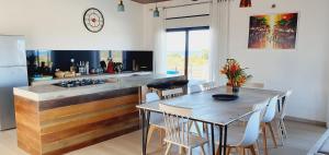 a kitchen with a counter and a table with chairs at Villa Vintana Nosy Be in Nosy Be