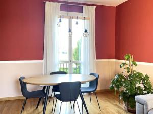 a dining room with red walls and a table and chairs at Appartamento moderno in Tenuta Melloni in Anzola dell'Emilia
