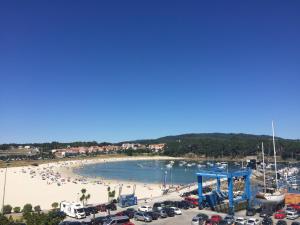 een strand met een stel mensen in het zand bij Hotel Varadoiro in Portonovo