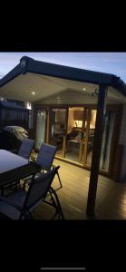 a deck with chairs and an umbrella on a house at The Luxury break Sleeps 6 at 44 Kingfisher Court South facing in Tattershall