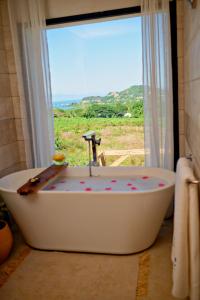 a bath tub in a bathroom with a window at Villa Vintana Nosy Be in Nosy Be