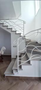 un escalier en colimaçon métallique dans un bâtiment blanc dans l'établissement Villetta panoramica con giardino, à Diamante