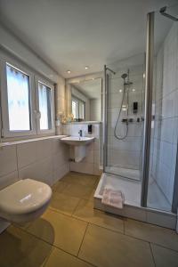 een badkamer met een douche, een toilet en een wastafel bij Hotel Tenner in Neustadt an der Weinstraße