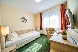 a hotel room with a bed and a table with wine glasses at Hotel Tenner in Neustadt an der Weinstraße
