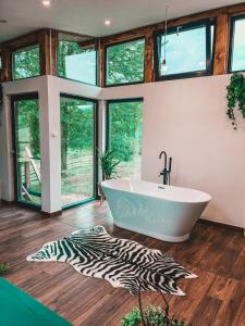 a bathroom with a tub and a zebra rug at Utopia by NorAtlas Heritage - Adults Only in Buzău