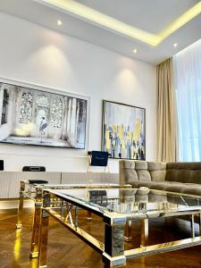 - un salon avec un canapé et une table en verre dans l'établissement MONDRIAN Luxury Suites & Apartments Market Square I, à Varsovie