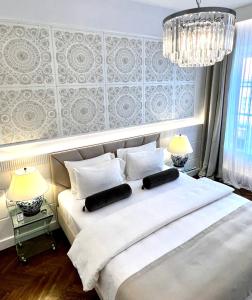 ワルシャワにあるMONDRIAN Luxury Suites & Apartments Market Square Iのベッドルーム(白い大型ベッド、ランプ2つ付)