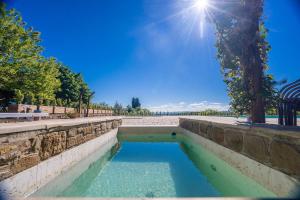 una pequeña piscina de agua en una pared de piedra en Agriturismo Relais Campiglioni, en Montevarchi