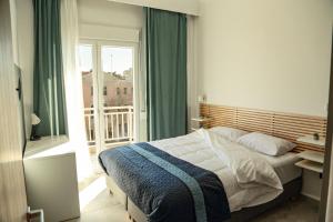 a bedroom with a bed and a large window at Urban Apartments in Komotini