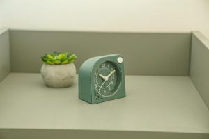 a clock sitting on a shelf with a potted plant at Urban Apartments in Komotini