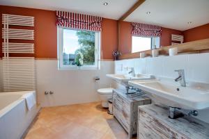 a bathroom with two sinks and a toilet and a window at Ferienhaus Seehof mit Sauna & offenem Kamin in Schliersee +21 photos