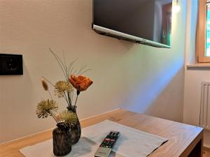 um vaso com flores e um controle remoto sobre uma mesa em Sonnenheim em Sonnberg