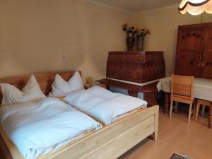 een slaapkamer met een bed met witte lakens en een piano bij Ferienwohnung Vertatschablick in Ferlach