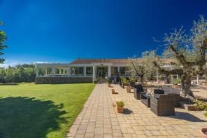 a house with a brick walkway in front of a yard at Agriturismo Relais Campiglioni in Montevarchi