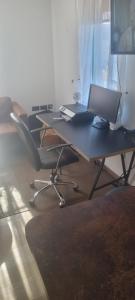 a desk with a laptop and a chair in a room at Papworth apartment in Papworth Everard