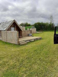 une cabane en bois dans un champ avec une table de pique-nique dans l'établissement Glamping at the Retreat Wiltshire is rural bliss, à Chippenham
