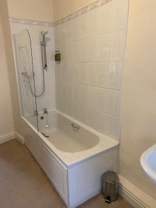 a white bathroom with a tub and a sink at George Hotel in Keswick