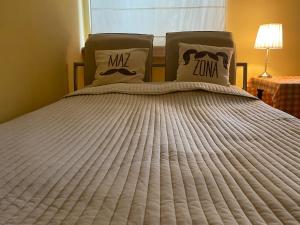 a bed with two pillows on top of it at Apartament u Maliny in Krynica Zdrój