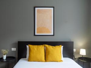 a bedroom with a bed with a yellow pillow at Downtown friendly studio in Bucharest