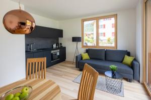 a living room with a couch and a table at am Greben Apartments eins - zwei - sechs - sieben in Bezau