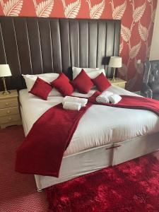 a bedroom with a large bed with red pillows at George Hotel in Keswick