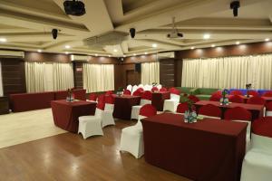 a banquet hall with tables and chairs in a room at Hotel Tea County in Dibrugarh