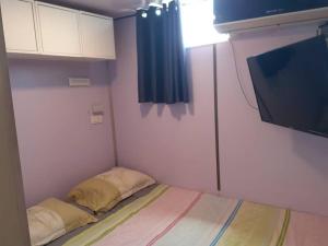 Habitación pequeña con cama y TV. en Luxury family caravan truck in the Golan Heights, en Bruchim Qela' Alon