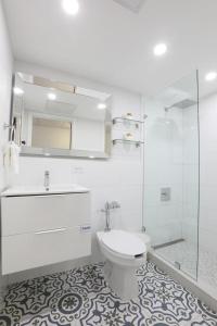 uma casa de banho branca com um WC e um chuveiro em San Juan Airport Hotel em San Juan
