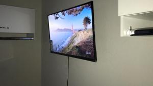 a flat screen tv hanging on a wall at Hostel Office- Hospedagem Climatizada quartos e apartamentos privativos in Extrema
