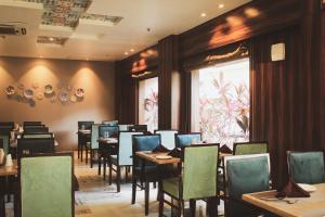 a dining room with tables and chairs and a window at Hotel Tea County in Dibrugarh