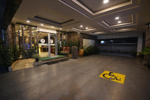 a lobby with a yellow sign on the floor at Hotel Tea County in Dibrugarh