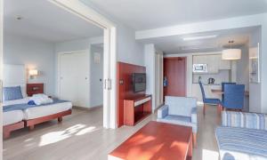カラ・ミラーにあるMarins Suites - Adults Only Hotelのベッドルーム1室(ベッド1台付)、リビングルームが備わります。