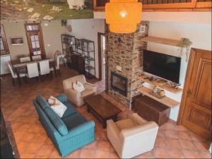 sala de estar con sofá y chimenea en Moretti Mountain House - Relax in Nature, en Gorreta