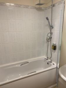 a bath tub in a bathroom with a shower at George Hotel in Keswick