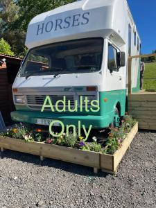 un camion-restaurant garé à côté d'un jardin fleuri dans l'établissement Pant y Rhedyn Glamping and camping site, à Abergele