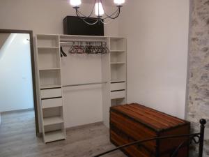 um armário com prateleiras brancas e um lustre em Joli appartement quartier Brassens 55 m2 à 2 mn du centre ville em Sète