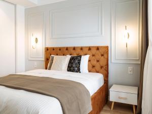 a bedroom with a large bed with a brown headboard at Elegant Cosy Studio - Calea Victoriei in Bucharest