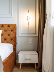a bedroom with a bed and a nightstand with a lamp at Elegant Cosy Studio - Calea Victoriei in Bucharest