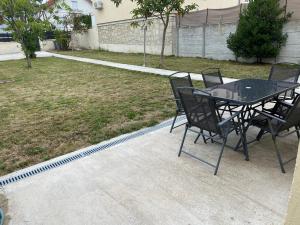 einen Tisch und Stühle neben einem Hof in der Unterkunft Maison proche de Paris/CDG et Disney in Villeparisis