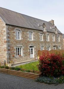 una gran casa de ladrillo con bancos delante en Maison de La Beslière meublé de tourisme 2 étoiles, en Folligny