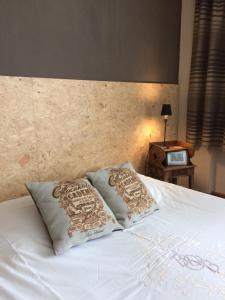 a white bed with two pillows on top of it at B&B Chambre Chocolat in Brussels